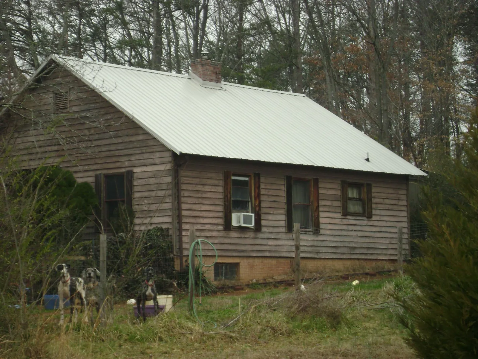 White metal roof on an old wood sided farmhouse, from a Metal Roof Installation job in Stratford